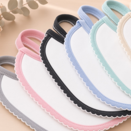 Pormenor dos bordos em picot dos babetes de algodão em cores cinza, rosa, preto, azul, verde-água e bege | ikisbaby